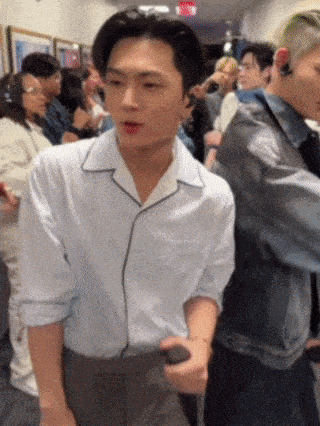 a man in a white shirt is standing in a crowd of people