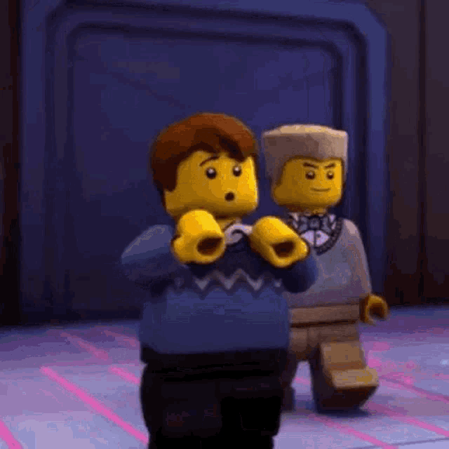 two lego ninjago characters are standing next to each other .