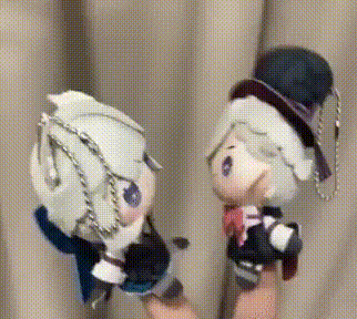 a person is holding two stuffed animals in their hand .