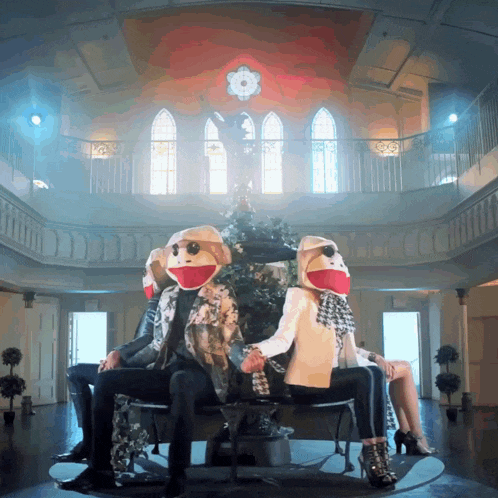 a man and a woman wearing monkey masks are sitting next to each other