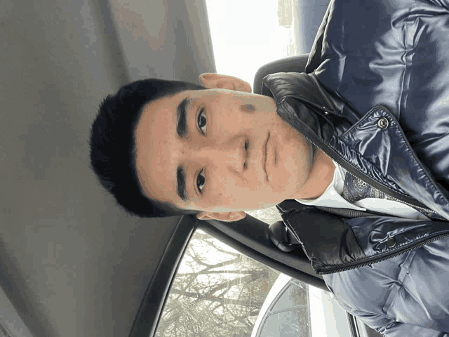 a man with a black spot on his face is wearing a black jacket