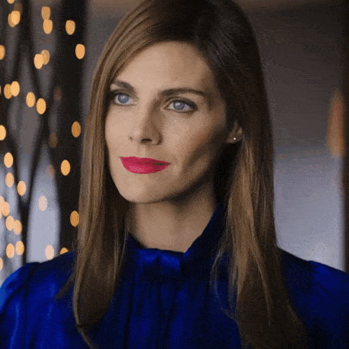 a woman in a blue top with red lipstick on her lips