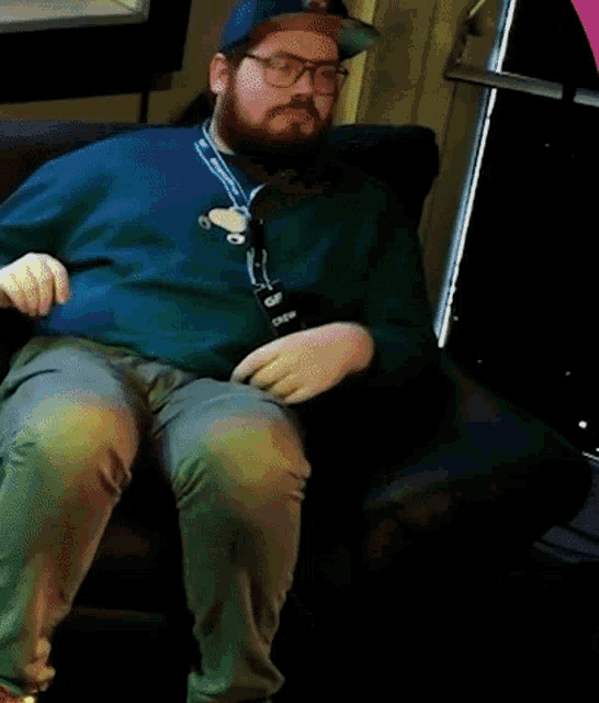 a man in a green shirt is sitting on a chair