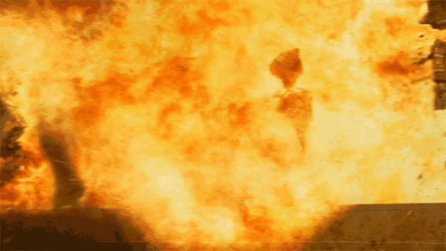 a person is standing in front of a wall of flames