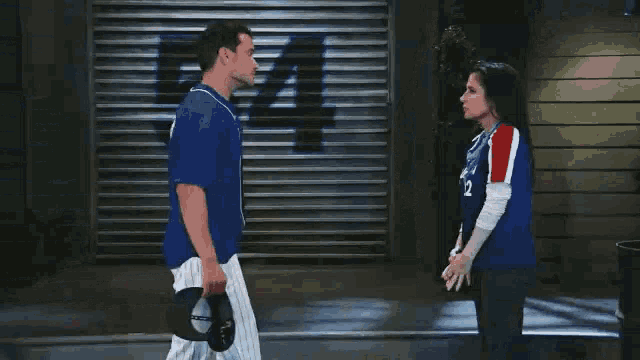 a man and a woman are standing next to each other in front of a garage door with the number 5 on it