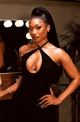 a woman is standing in front of a mirror wearing a black dress .