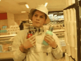 a man wearing a white hat holds a bottle of soda