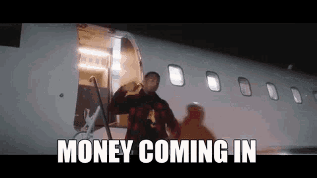 a man is standing in front of an airplane with the words money coming in written on the bottom .