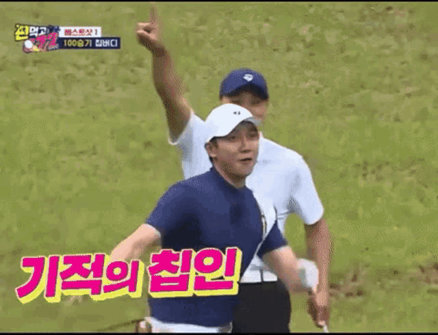 a man holding a golf club on a golf course with korean writing on the screen