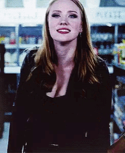 a woman in a black top stands in front of a sign that says ' ice cream '