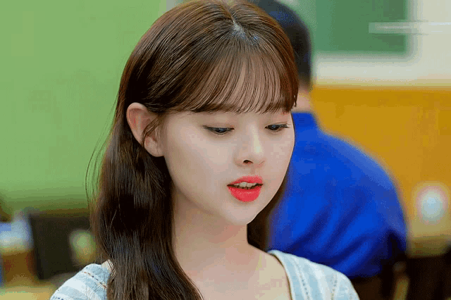 a woman with red lipstick on her lips looks at the camera