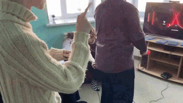 a woman in a white sweater is holding a wii controller
