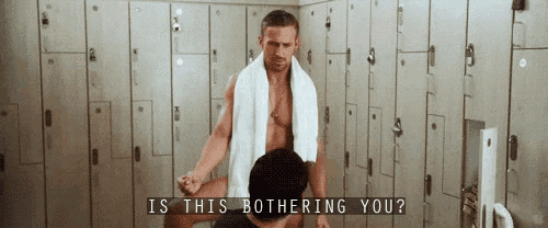 a man with a towel around his neck is standing in a locker room with a woman .