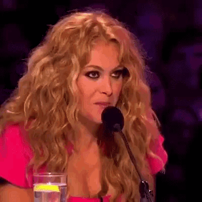 a woman in a pink dress is sitting in front of a microphone