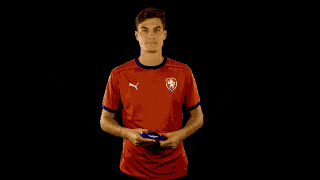 a man wearing a red shirt with a czech emblem on it