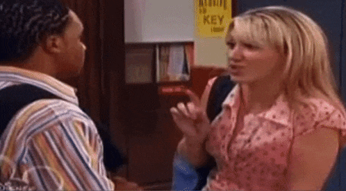a man and a woman are standing next to each other in a hallway .
