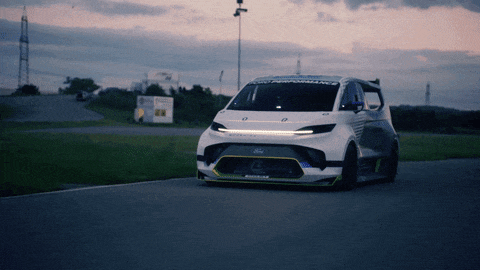 a ford car is driving down a road at night
