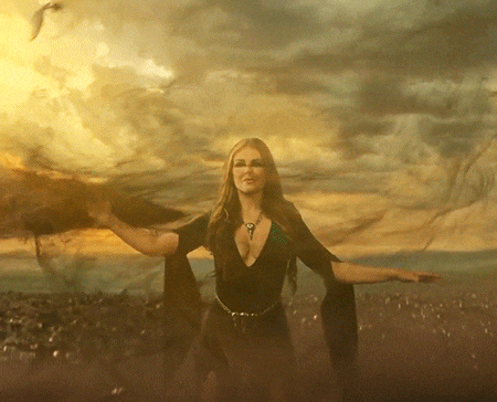 a woman stands in front of a cloudy sky