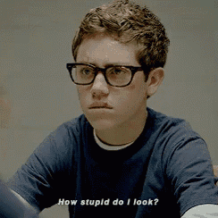 a young man wearing glasses and a blue shirt is asking how stupid do i look