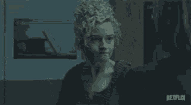 a man and a woman are sitting in a dark room looking at a computer screen .