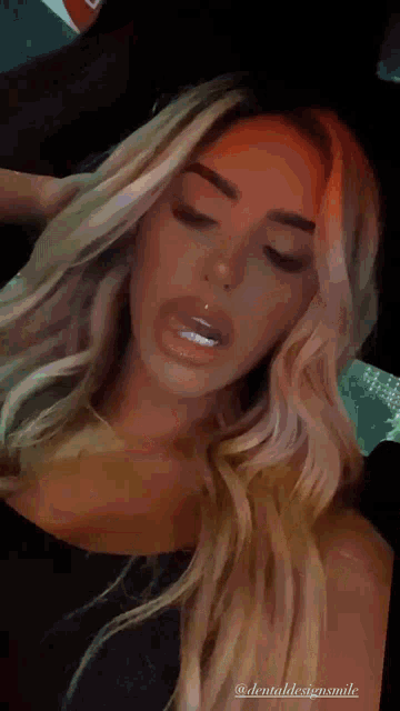 a close up of a woman 's face with the words " dentaldesignsmile " on the bottom right