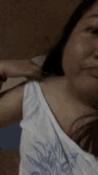 a woman in a white tank top with a blue leaf on it