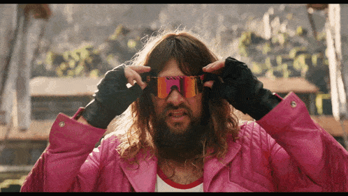 a man with long hair and a beard wearing sunglasses