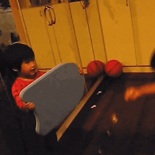 a little boy is holding a blue foam board in his hands