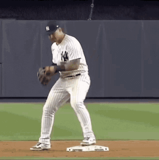 a new york yankees baseball player is getting ready to catch a ball