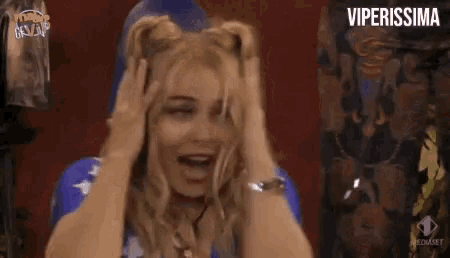 a woman is holding her hair in a ponytail while laughing .