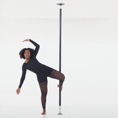 a woman is standing on a pole with one leg up