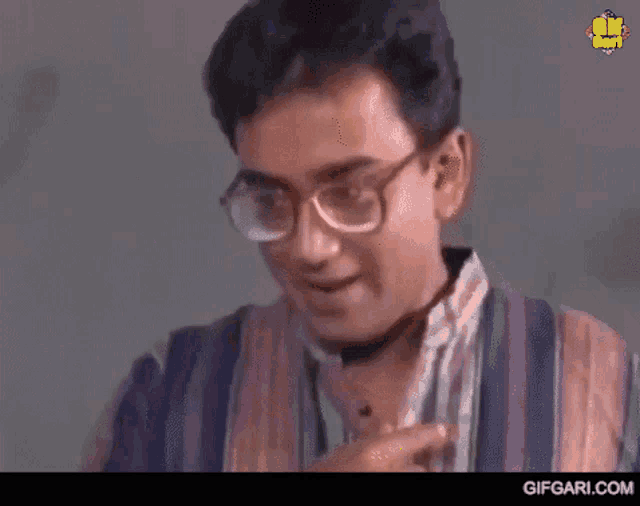 a man with glasses covering his mouth with his hands