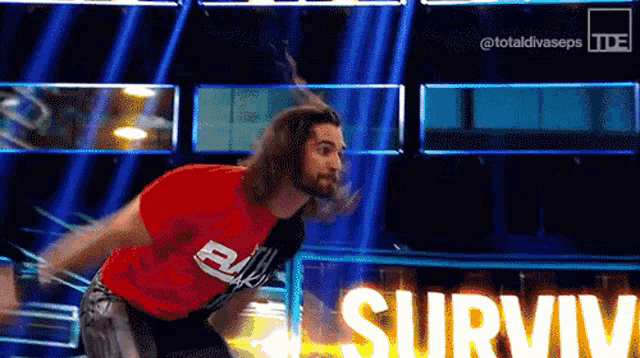 a man in a red shirt is jumping in the air with the word survive in the background