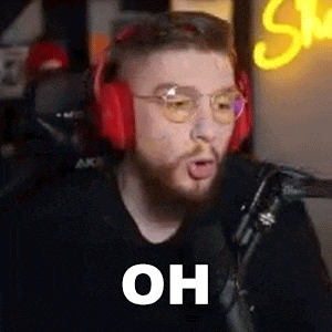 a man wearing headphones and glasses is talking into a microphone and making a funny face .