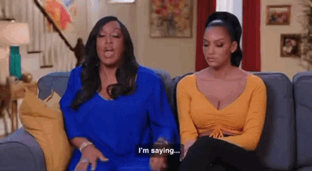 two women are sitting on a couch and one of them is saying i 'm saying ...