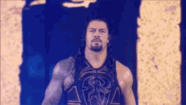 roman reigns is wearing a black tank top with a lion on it .