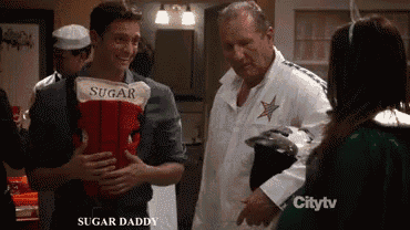 a man in a sugar daddy costume talks to another man