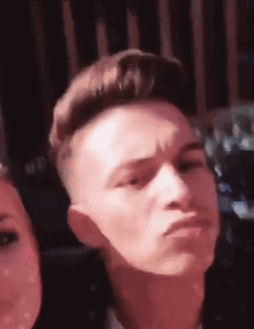 a close up of a man making a funny face next to a woman .