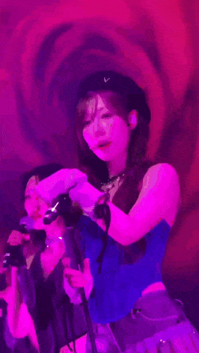two women are singing into microphones in front of a red rose .