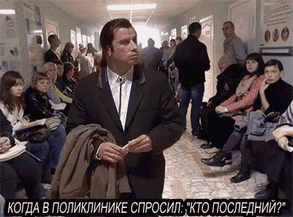 a man in a suit is standing in front of a crowd of people in a hospital hallway ..
