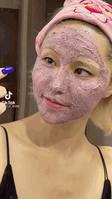 a woman wearing a pink panther headband and a purple face mask .