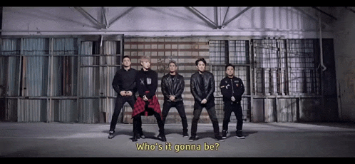 a group of men are standing in front of a wall and the question who 's it gonna be appears