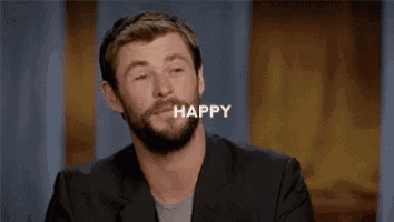 a man with a beard is smiling with the word happy written above him .