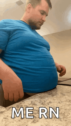 a man in a blue shirt is sitting on a counter with the words mern written on the bottom