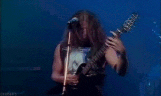 a man is playing a guitar and singing into a microphone