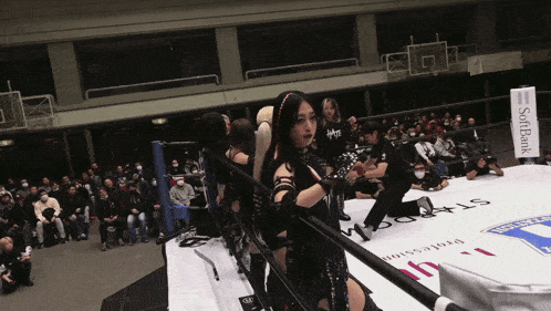 a woman in a wrestling ring with a sign that says softbank