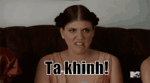 a woman is sitting on a couch making a funny face and saying ta khinh .