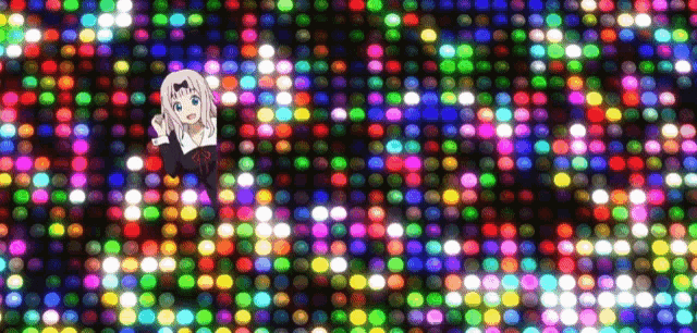 a girl is standing in front of a wall of colored lights