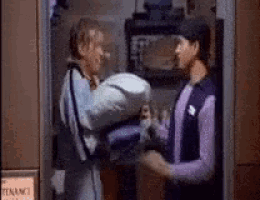 two men are standing next to each other in a locker room .