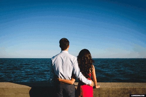 a man and a woman looking at the ocean with jl wedding.com written on the bottom right